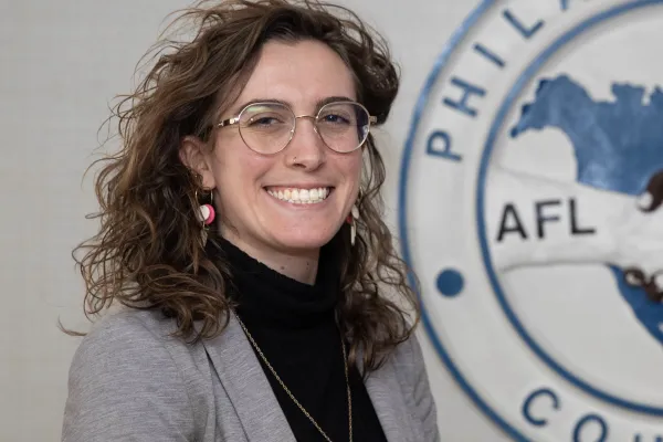 A woman standing to the left of the Philadelphia AFL-CIO logo