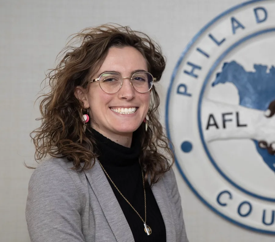 A woman standing to the left of the Philadelphia AFL-CIO logo