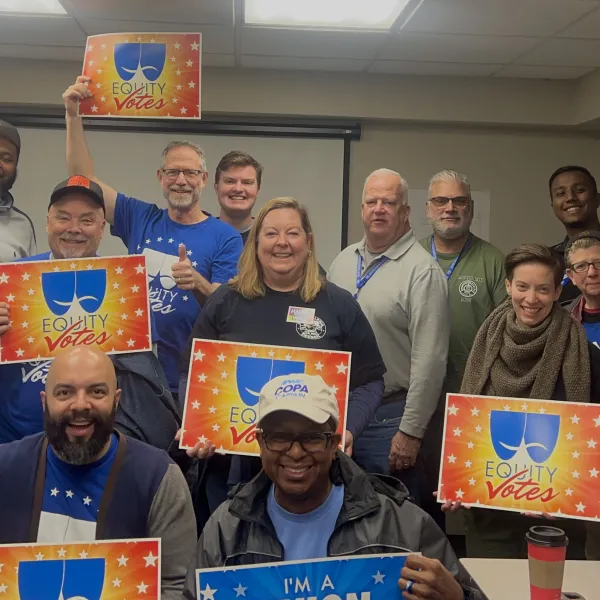 Union members holding signs that say “union voter” and “Equity votes!”
