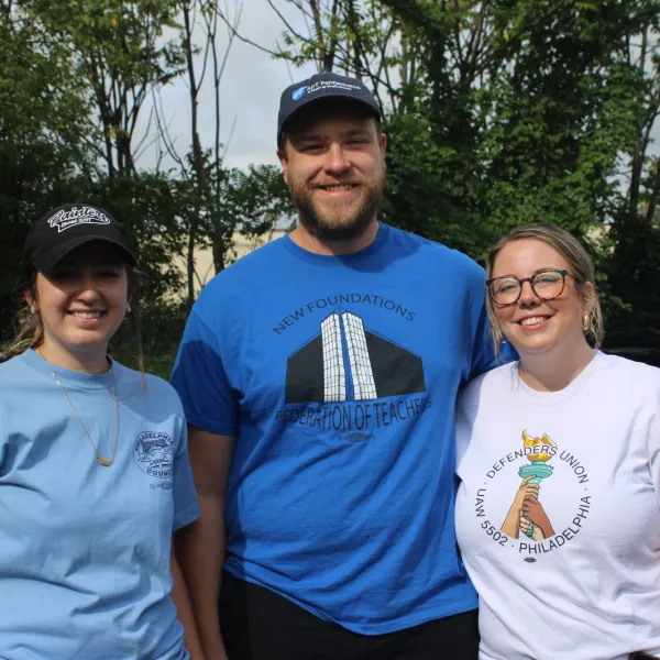 A man and two women smile together at a canvass launch
