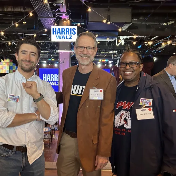 Three men stand together at a campaign rally